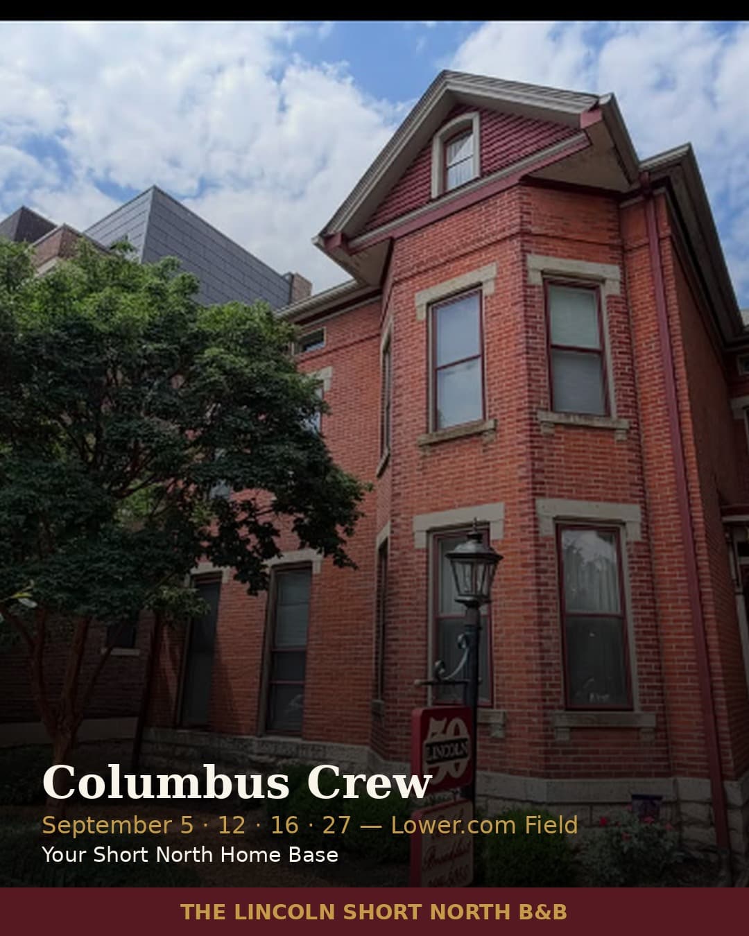 A red brick bed and breakfast building surrounded by trees, featuring a lamp post and signage for the Columbus Crew.