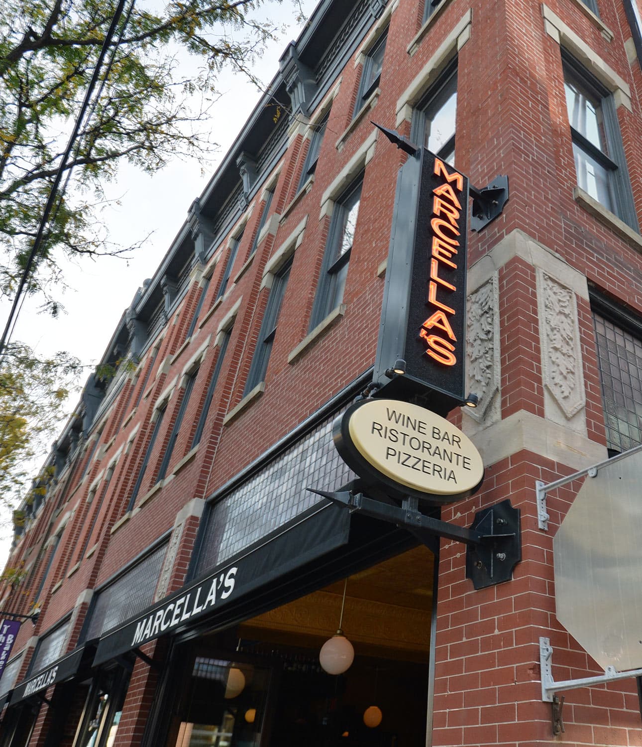 A brick building with a sign for Marcella's Wine Bar, Ristorante, and Pizzeria.